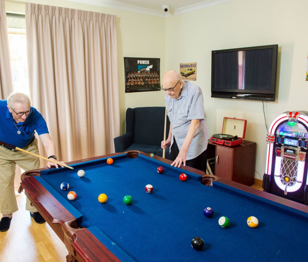 Eldercare Evanston Park residents playing pool in a games room.
