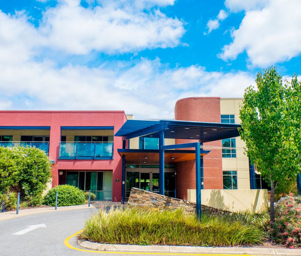 Entrance of Eldercare Evanston Park against a blue sky with fluffy clouds.