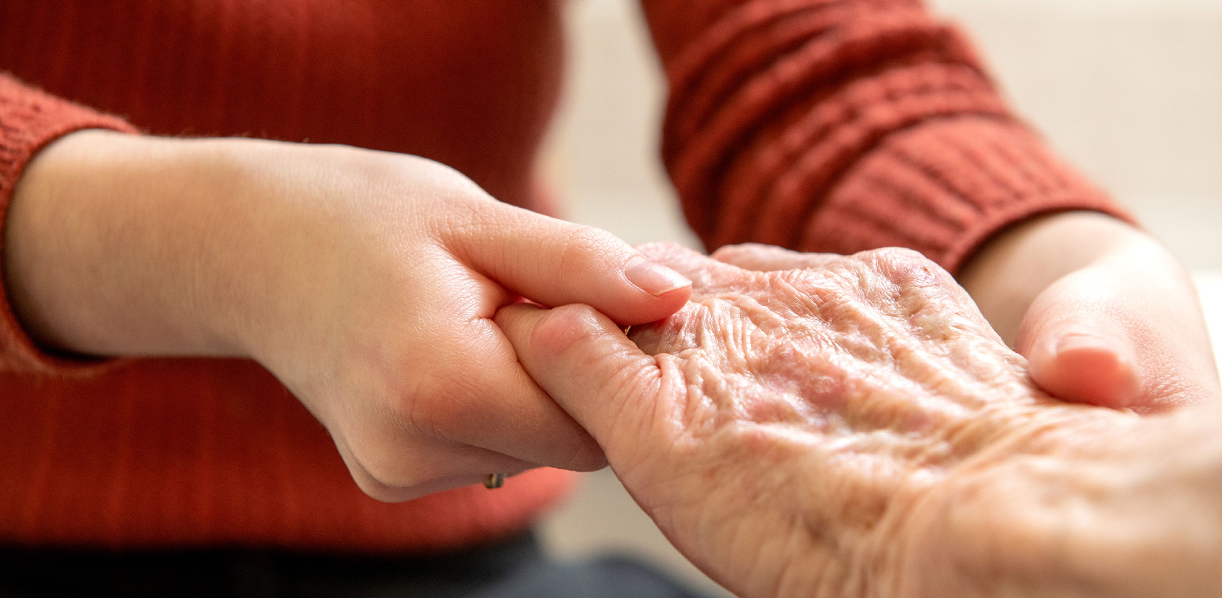 An older person's hand is being massaged by a physiotherapist.
