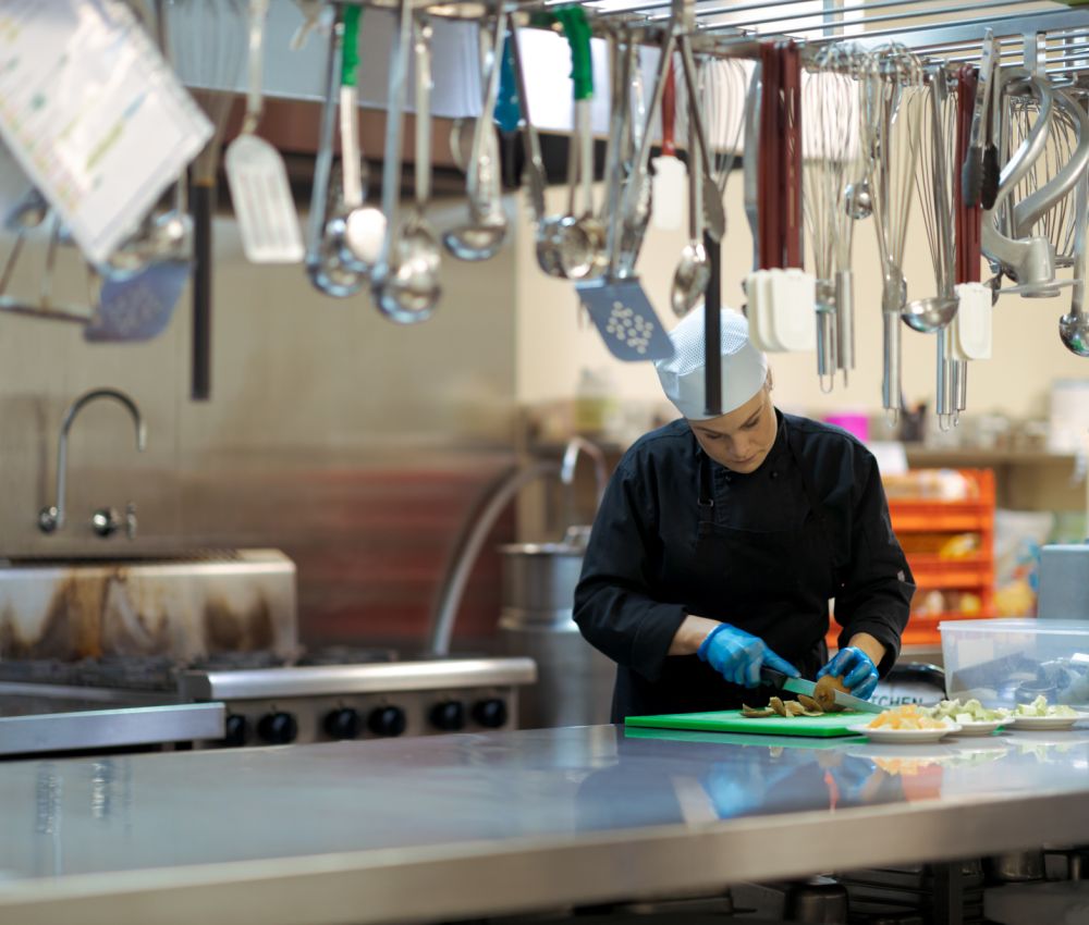 An Eldercare chef prepares vegetables in the industrial kitchen at Allambi.