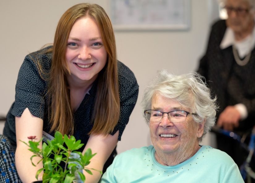 Eldercare resident and staff member at a gardening group.