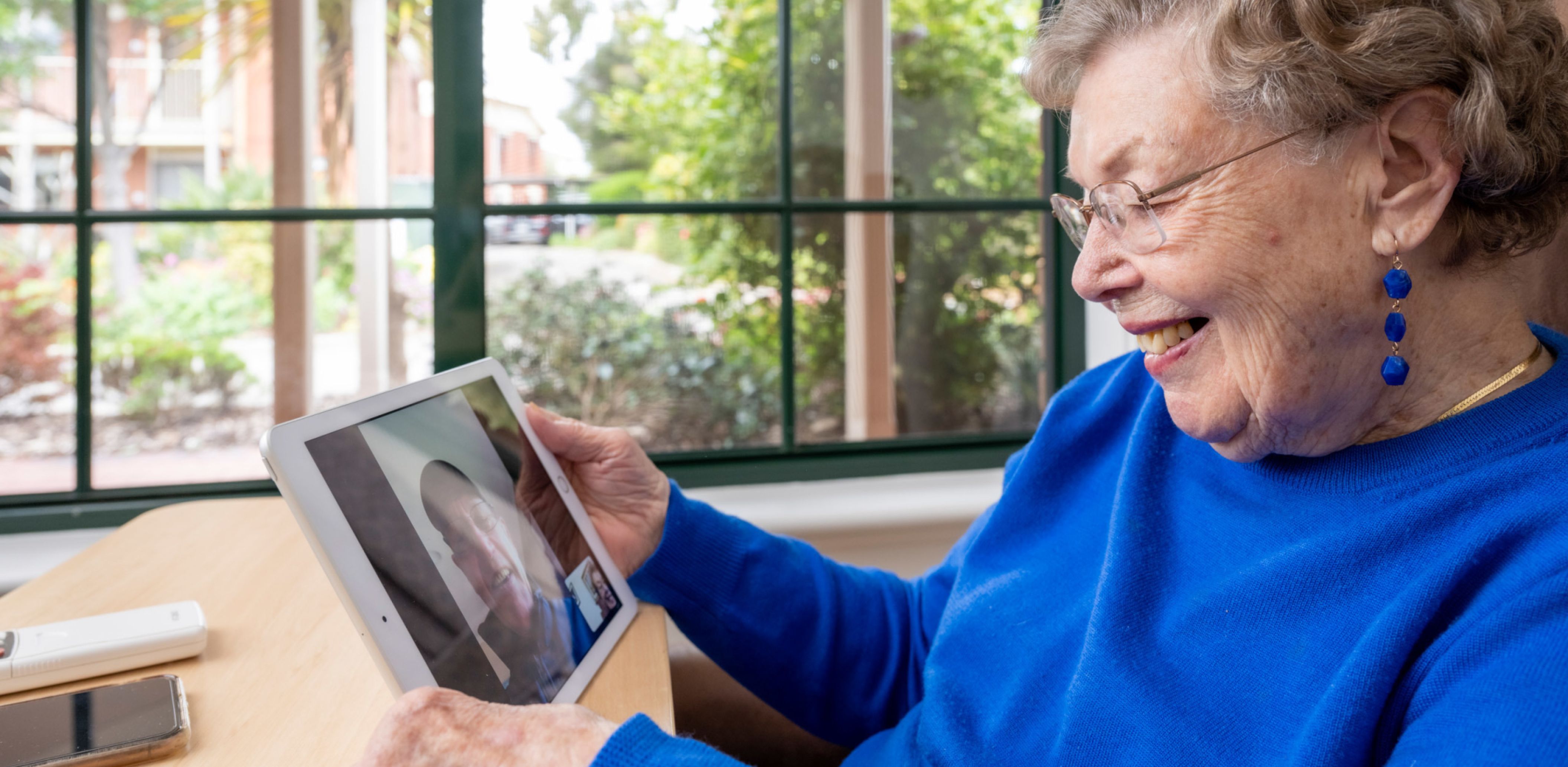 Oxford Resident smiles whilst talking to her son via Skype.