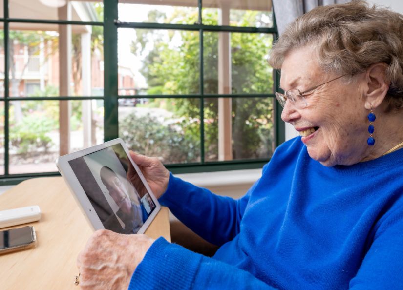 Oxford Resident smiles whilst talking to her son via Skype.