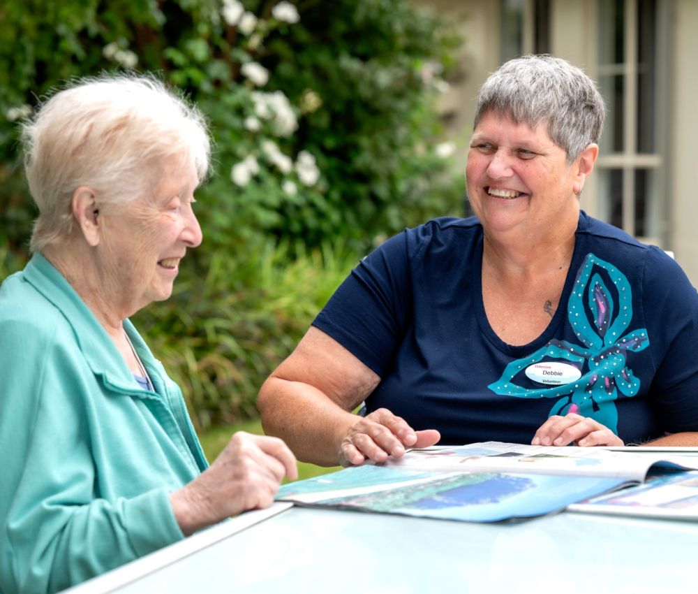 Eldercare volunteer smiling with a resident.