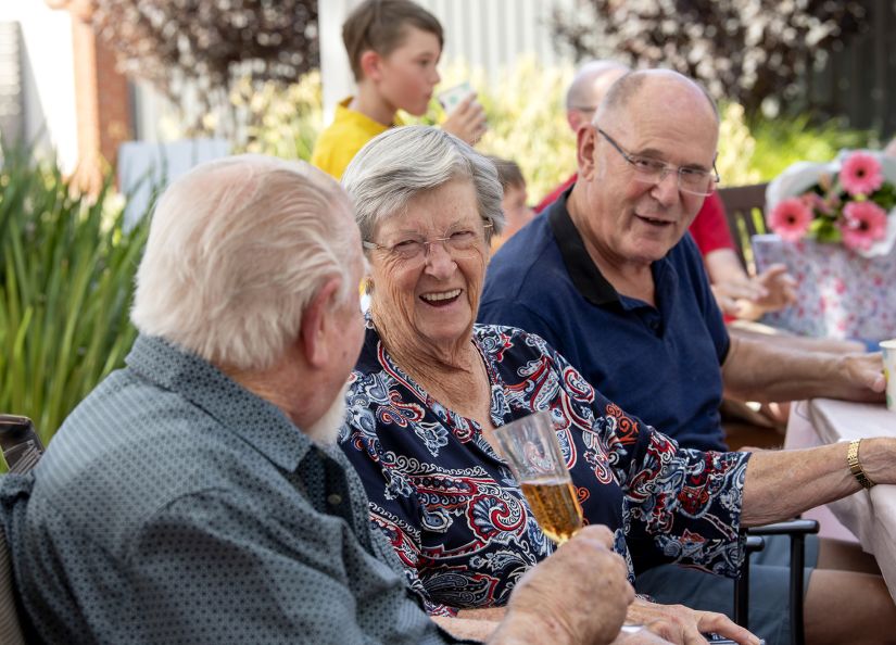 Eldercare Mulberry Grove Retirement Living residents talking and smiling at each other.