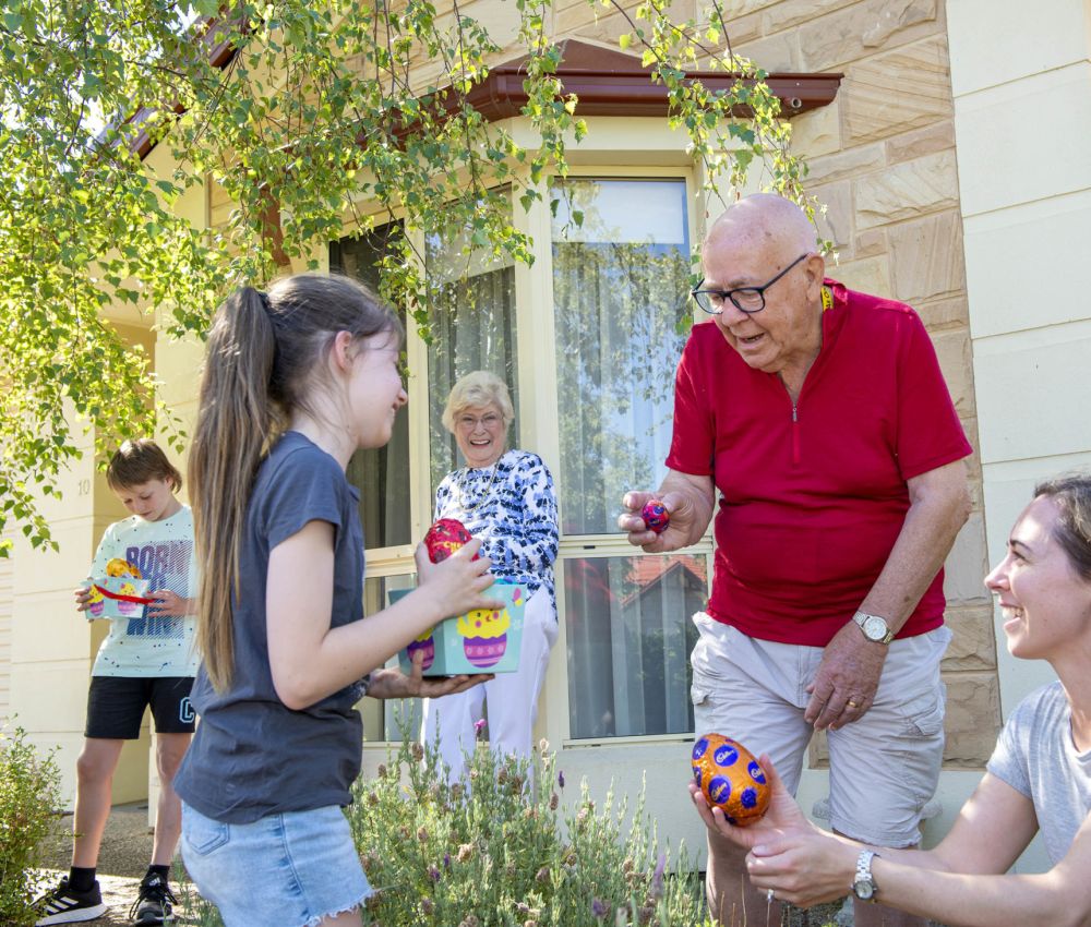 Eldercare Exhibition Court Retirement Living residents and family members exchanging Easter eggs.