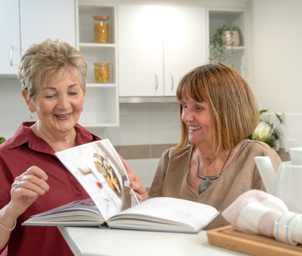 Eldercare Kingsborough Retirement Living residents reading a cooking book.